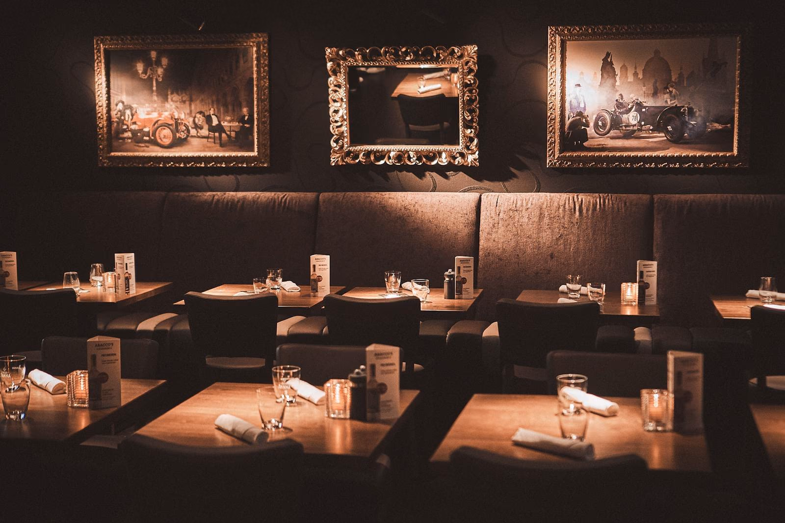 Gastraum von Abacco’s Steakhouse Wien mit gedeckten Tischen und gerahmten Bildern