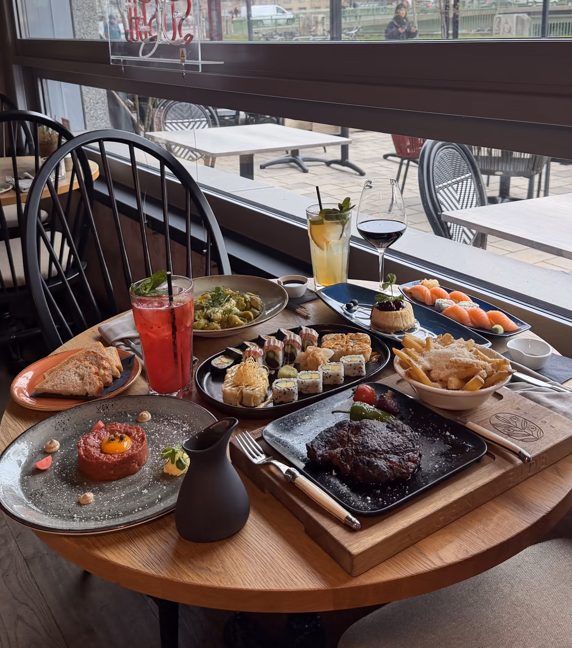 Gedeckter Fenstertisch in der Augenweide Wien mit Steak, Sushi, Beef Tatar und Trüffel-Pommes