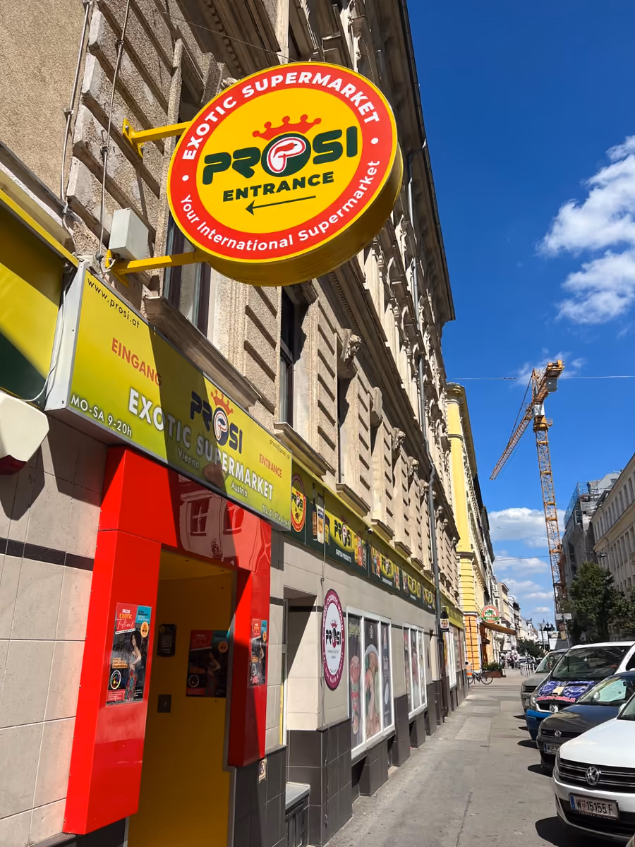 Eingang und gelb-rotes Prosi-Schild an der Fassade des Supermarkts in Wien