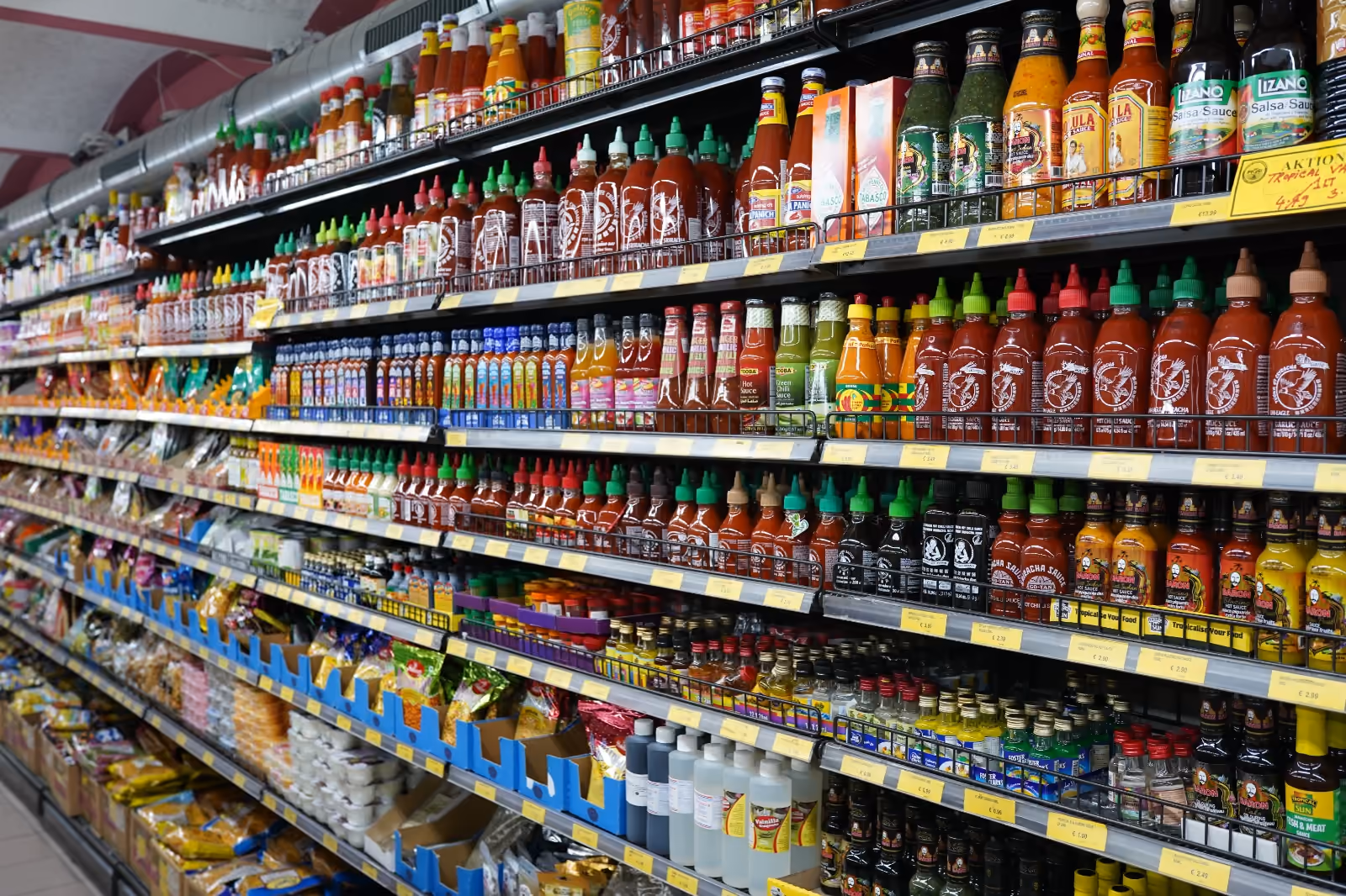 Regal mit internationalen Chilisaucen, Gewürzen und weiteren Lebensmitteln bei Prosi